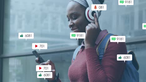 animation of social media icons with growing numbers over african american woman using smartphone