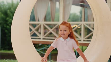 smiling girl in pink dress sitting on outdoor circle