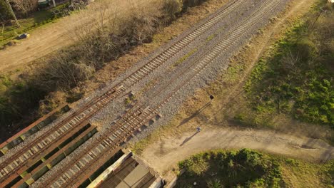 aerial - father and son walking next to railway in maschwitz, argentina