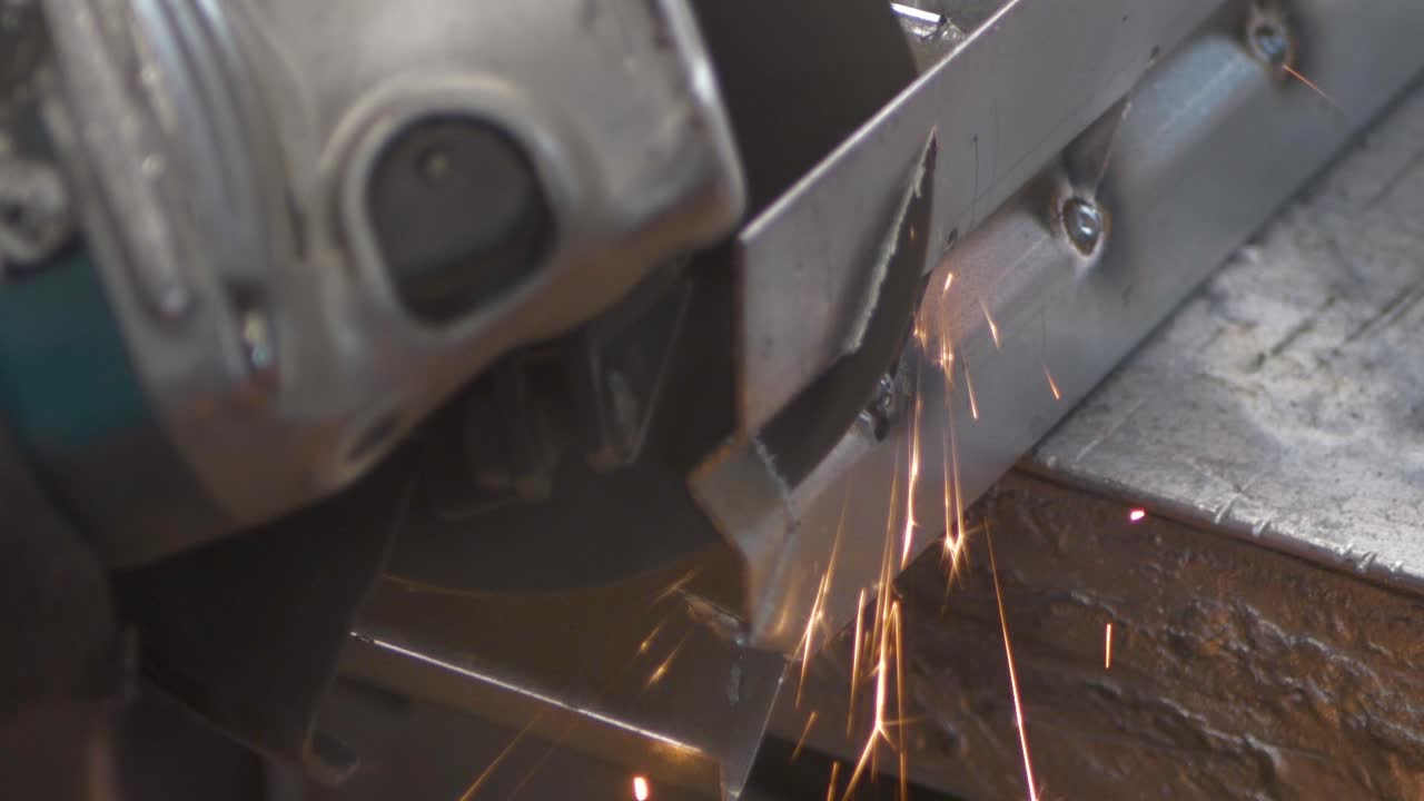 Impressive spark shower of angular metal cutting. A metal worker is cleaning the rusty surface of a steel sheet. Slow motion