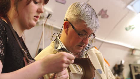 apprentice in bespoke shoemaker glueing together leather