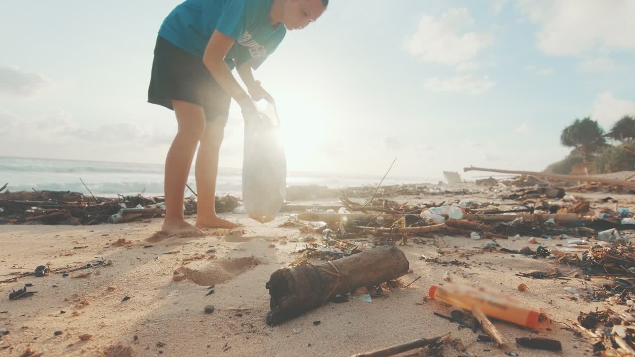 젊은 백인 여성 자원봉사자가 바가에서 플라스틱 쓰레기를 청소하고 있습니다.