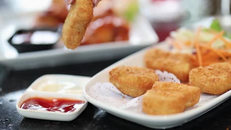 nuggets being dipped in various sauces