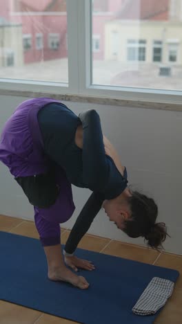 woman practicing yoga pose on a balcony