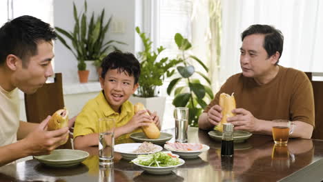 Hombres-Asiáticos-Y-Niño-Sentado-En-La-Mesa