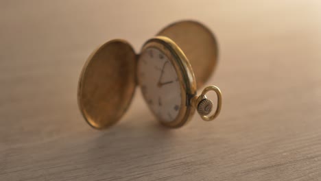 push-in to focus on an antique pocket watch propped open on a light grey desk