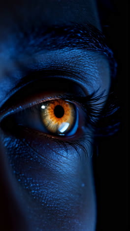 close-up of a mysterious orange eye in dark blue light