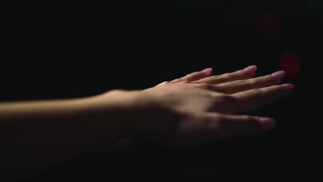 Beautiful-woman-hand-laying-on-glossy-surface-indoors.Macro-manicured-pink-nails