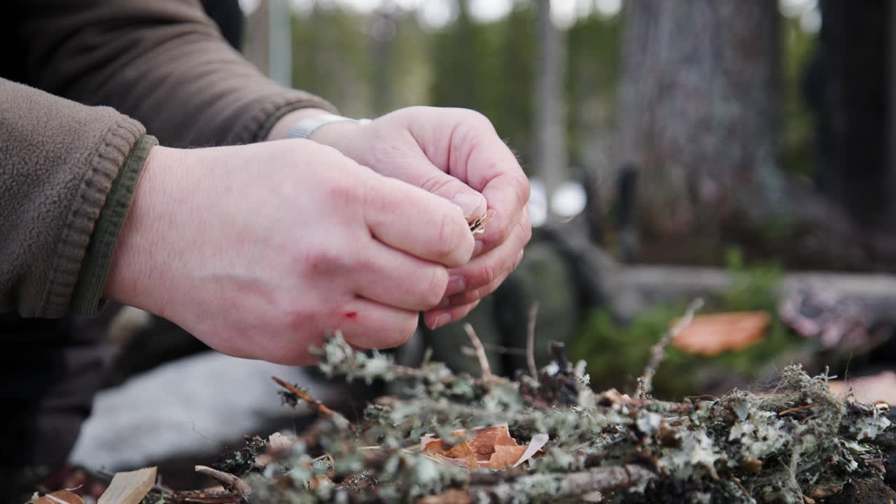 Man preparing fire with small pieces of birchwood