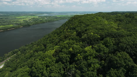 Natural-splendor-of-Minnesota,-Great-River-Bluffs-State-Park,-verdant-forest-overlooking-Mississippi-River---aerial