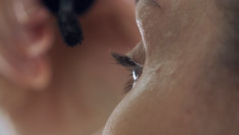 primer plano mujer madura aplicar delineador de ojos