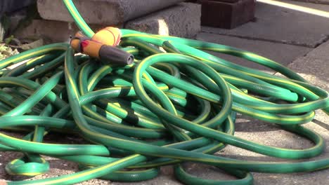 hosepipe lying unused on an english garden patio during the water shortage