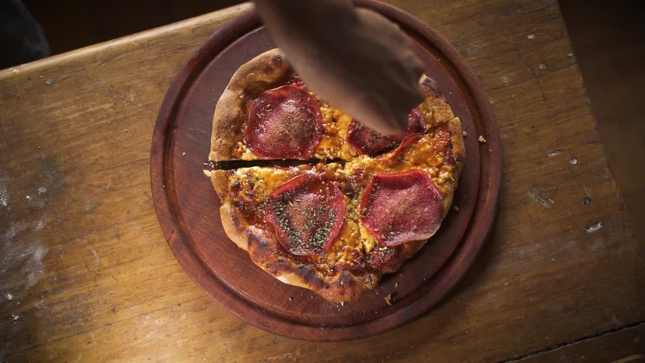 condimento caliente ahumado deliciosa pizza casera de pepperoni en la vista superior de la mesa de madera cámara lenta 60fps