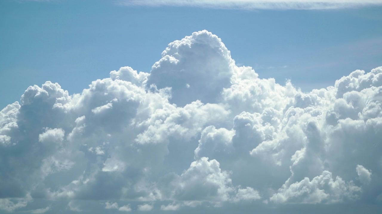 青く明るい空に速く動く厚い白い雲の4Kタイムラプス