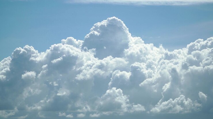 Time lapse of fast moving thick white clouds in a blue bright sky in 4K quality