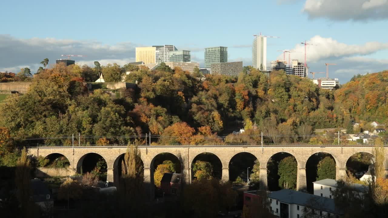 Efterårsbylandskab med skyline og historisk stenbro