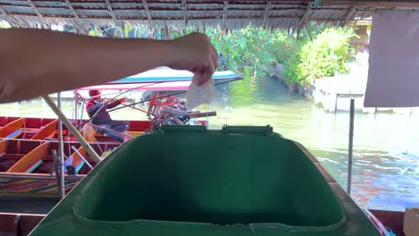 throwing trash in bin at bangkok market