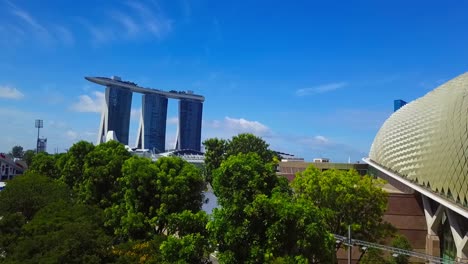 aerial drone shot rising to reveal marina bay sands, the singapore river, and the futuristic technological skyline on a clear day