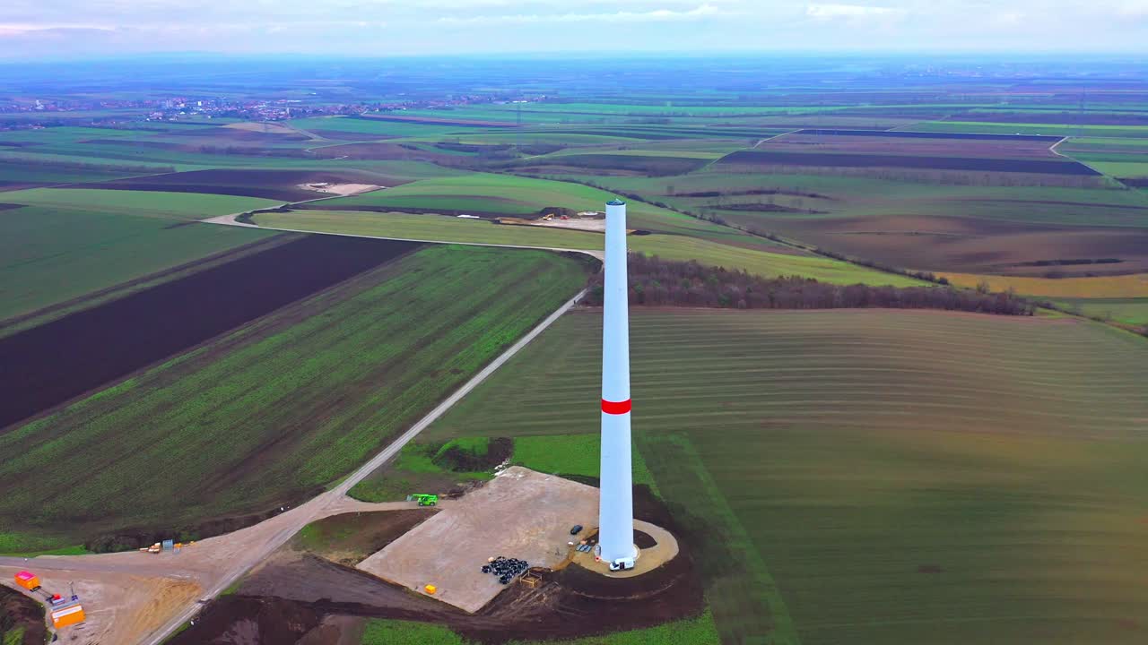 construcción de una torre de turbinas eólicas en el campo de la granja - toma aérea de drones