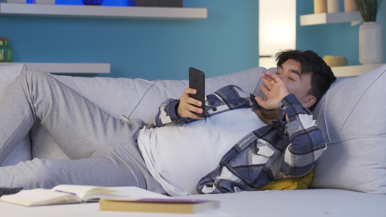 손에  ⁇ 드폰을 들고 밤에 잠들어 있는 남자.  ⁇ 드폰 중독.