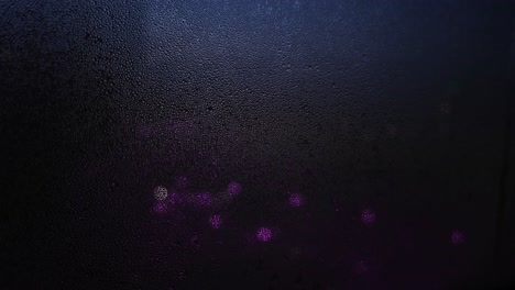 vista nocturna a través de una ventana de niebla con luces púrpuras
