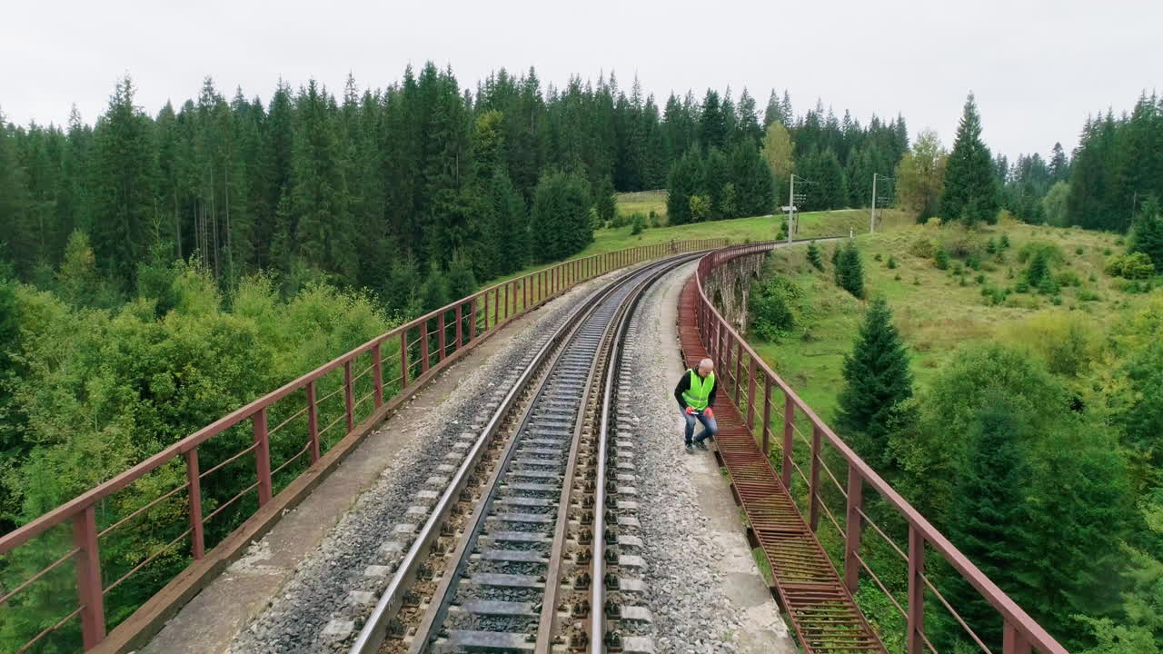 persona caminando por el puente ferroviario a través del bosque