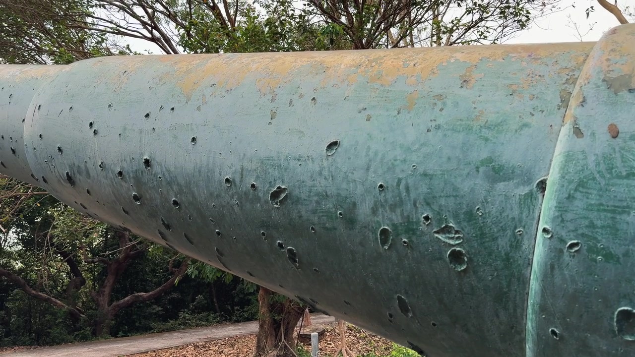 Nærbillede af et mørtelkanonløb, et militært levn, med historisk udsigt over Corregidor Island, Manila