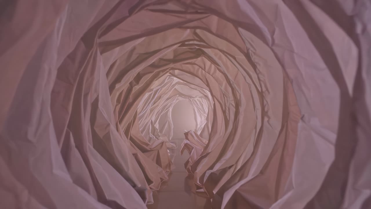 Soft, translucent fabric drapes form a tunnel, creating a mesmerizing and dreamy atmosphere with warm, inviting light filtering through the delicate layers