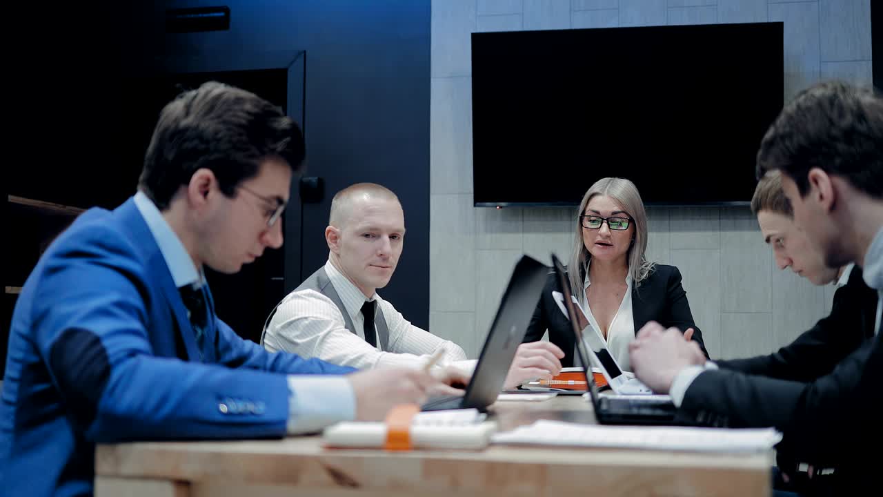 아름다운 여성 상사가 회의를 위해 동료들을 비난합니다. 종이를 파트너에게 던지고 그에게 소리를 지릅니다.