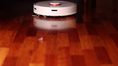 smart robot vacuum cleaner with lidar on wood floor. robot vacuum cleaner performs automatic cleaning of the apartment. slow motion 100 fps. ungraded video