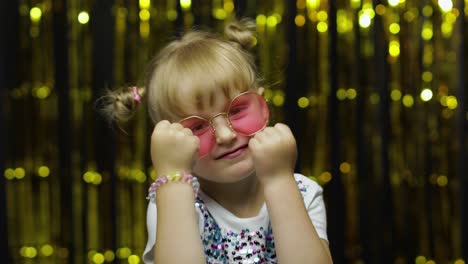 niño gracioso tratando de pelear en la cámara, boxeo con expresión. niña posando en un fondo brillante