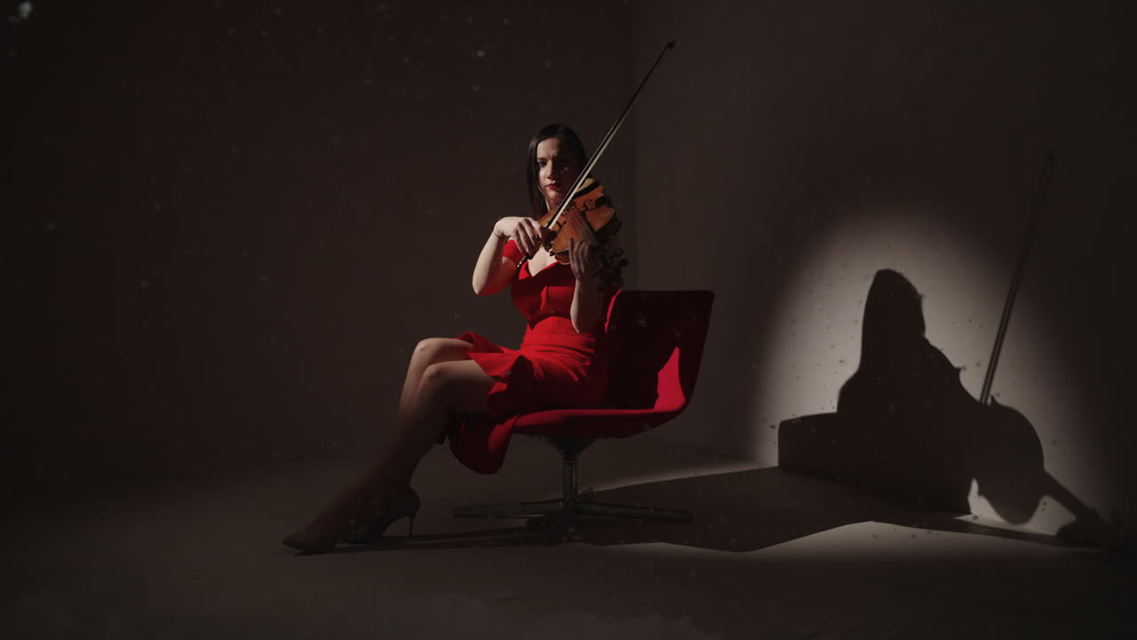 mujer tocando el violín en vestido rojo