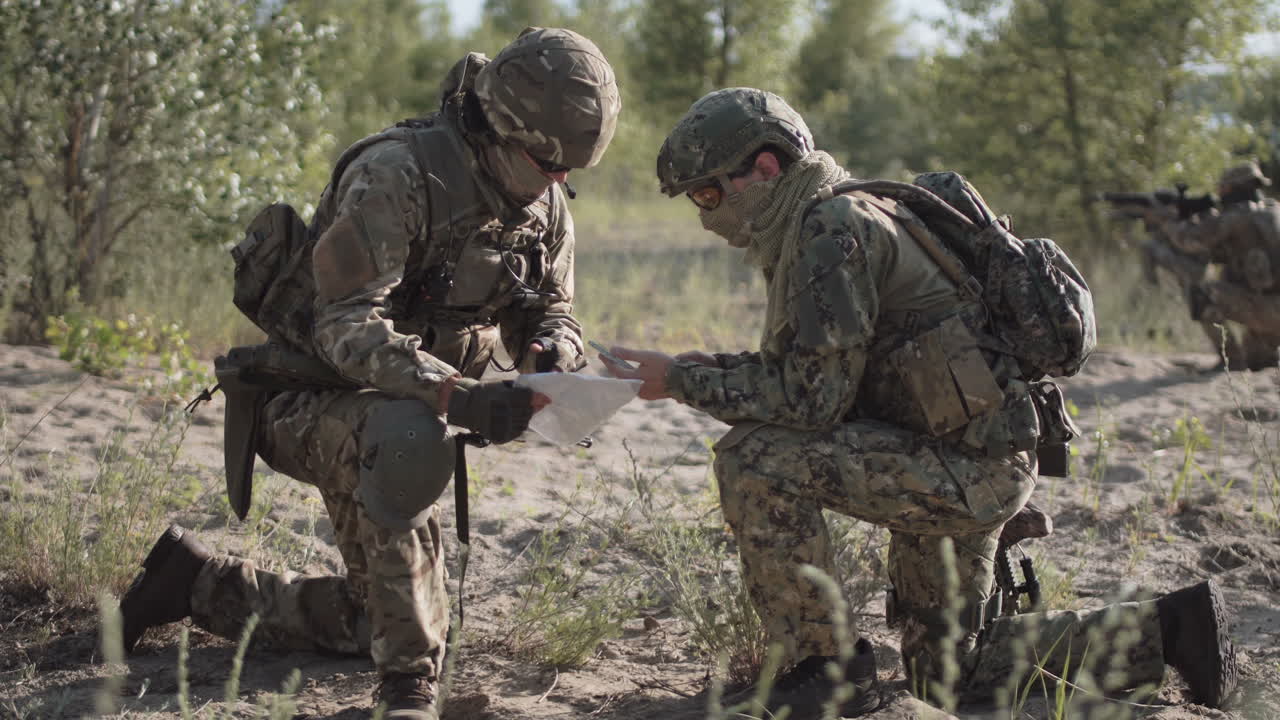 Military personnel reviewing a map in the field