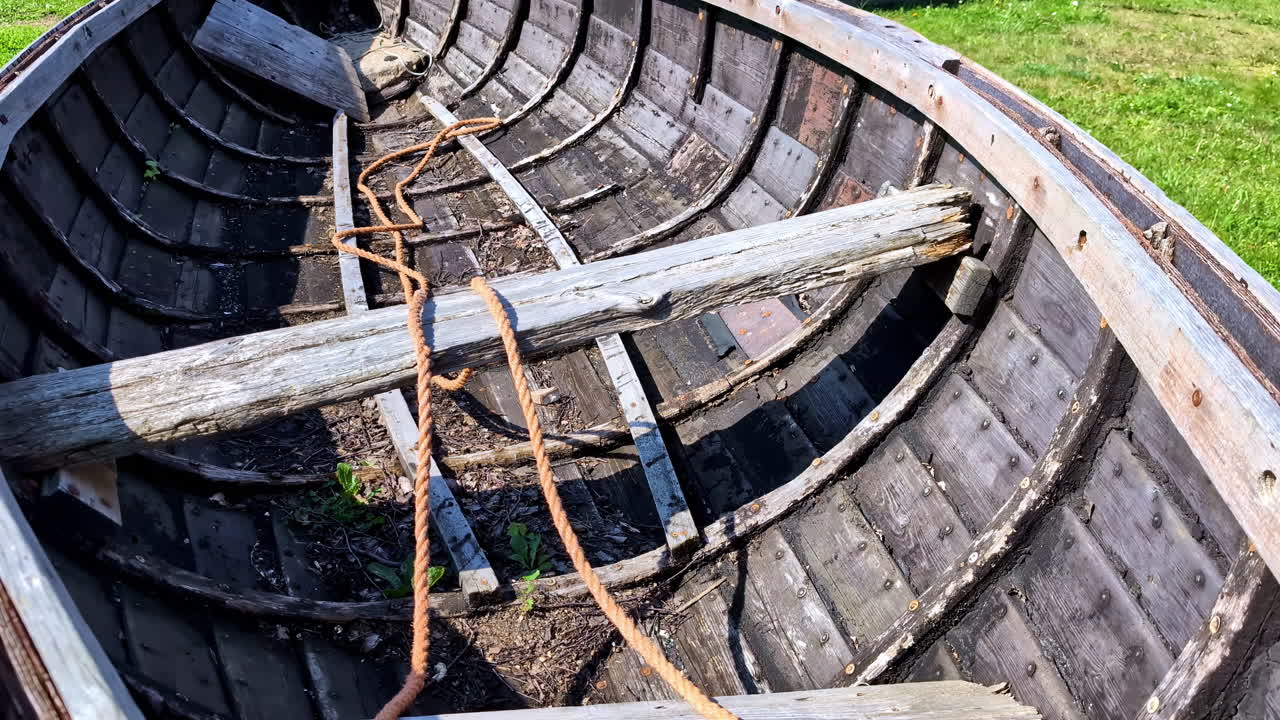 이 많은 풀 위에 나무로 만든 배가 폐허가 되었습니다.