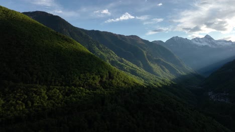 日光照射在意大利高山山谷的綠色山坡上