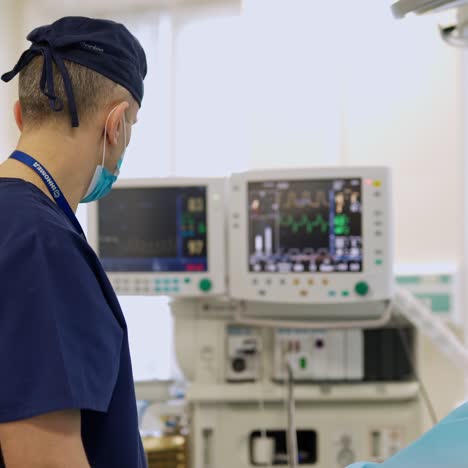 medical worker looking on the monitors during surgery. screen of monitors showing vital signs of a patient. modern operating theater in the hospital.