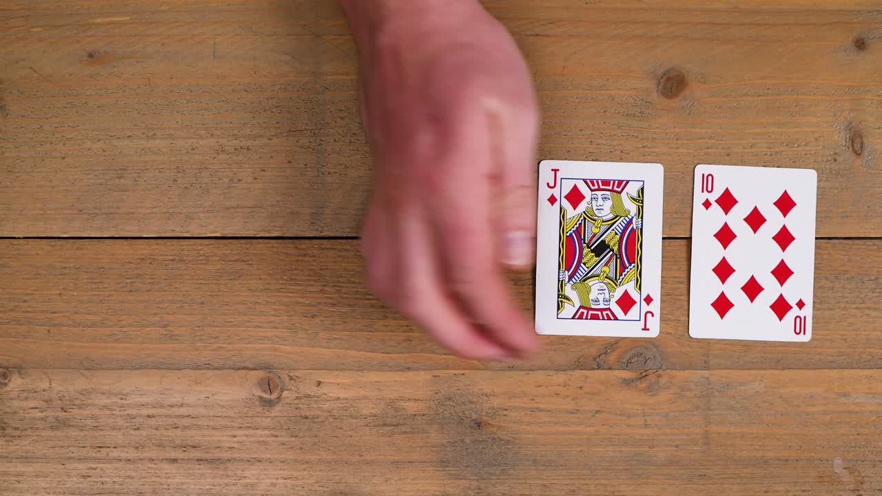 una persona que coloca un royal flush con diamantes en una mesa de madera para educar al espectador sobre cómo jugar al póquer