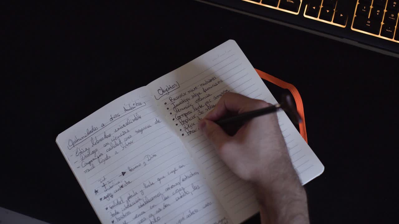 Detail shot of handsome young man writing