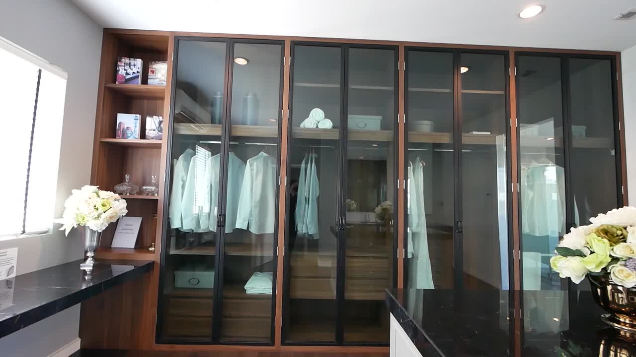 Modern Walk-in Closet with Glass Doors and Wood Accents