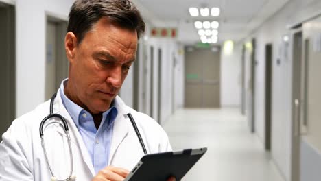 doctor using digital tablet in corridor