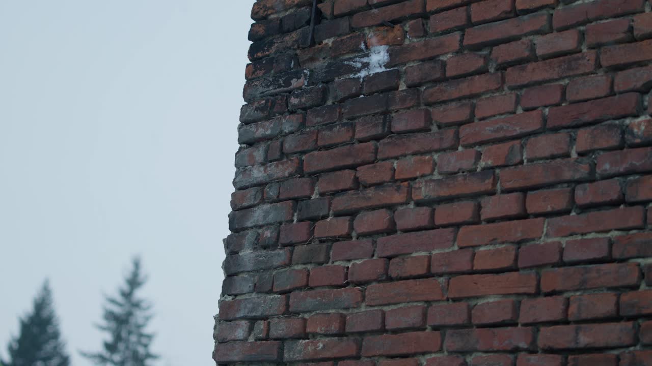 bolas de nieve en cámara lenta golpeando y salpicando una pared de piedra de ladrillo rojo