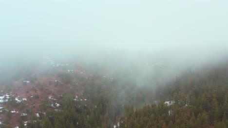 Aerial-truck-shot-slowly-flying-through-clouds-over-a-mountain