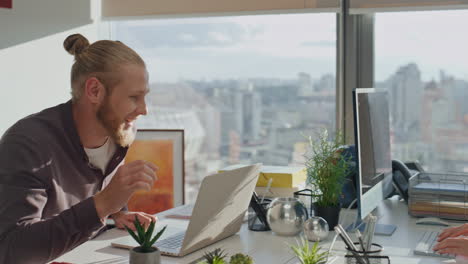 Young-team-laughing-office-table-closeup.-Creative-startupers-exchanging-ideas