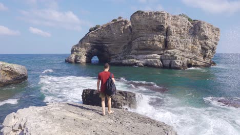 el hombre mirando el mar en el borde del acantilado.