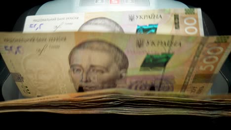 billetes de hryvnia ucraniana siendo contados por una máquina