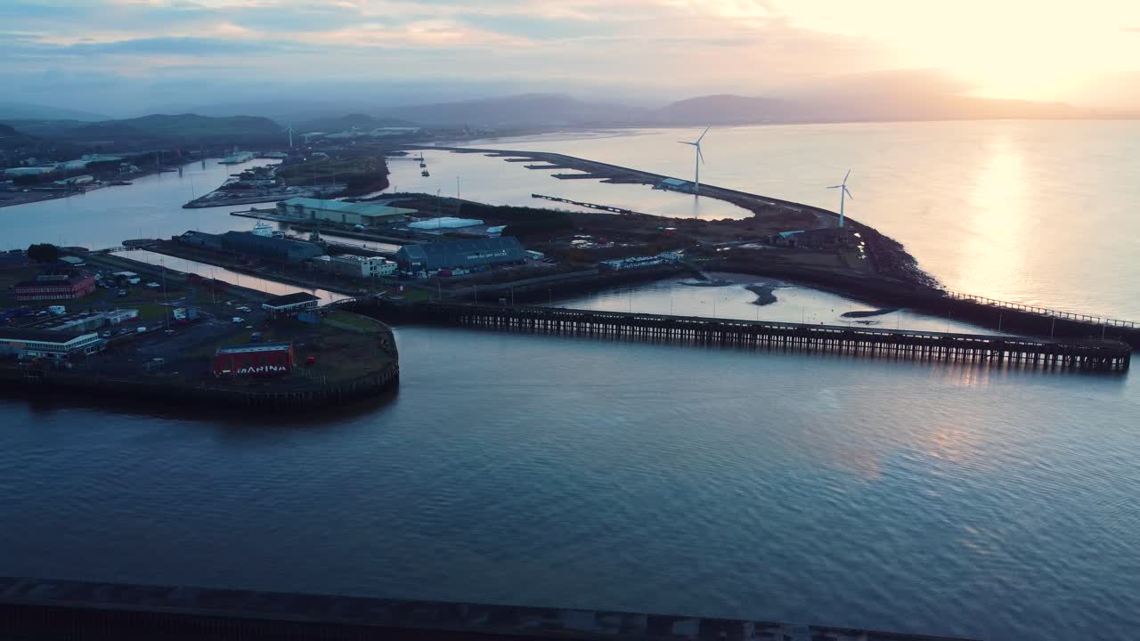 Vista aerea grandangolare dei Docks di Swansea all'alba con la luce dell'ora d'oro. Paesaggio portuale industriale marittimo per l'attracco di merci trasportate e la riparazione e manutenzione di imbarcazioni