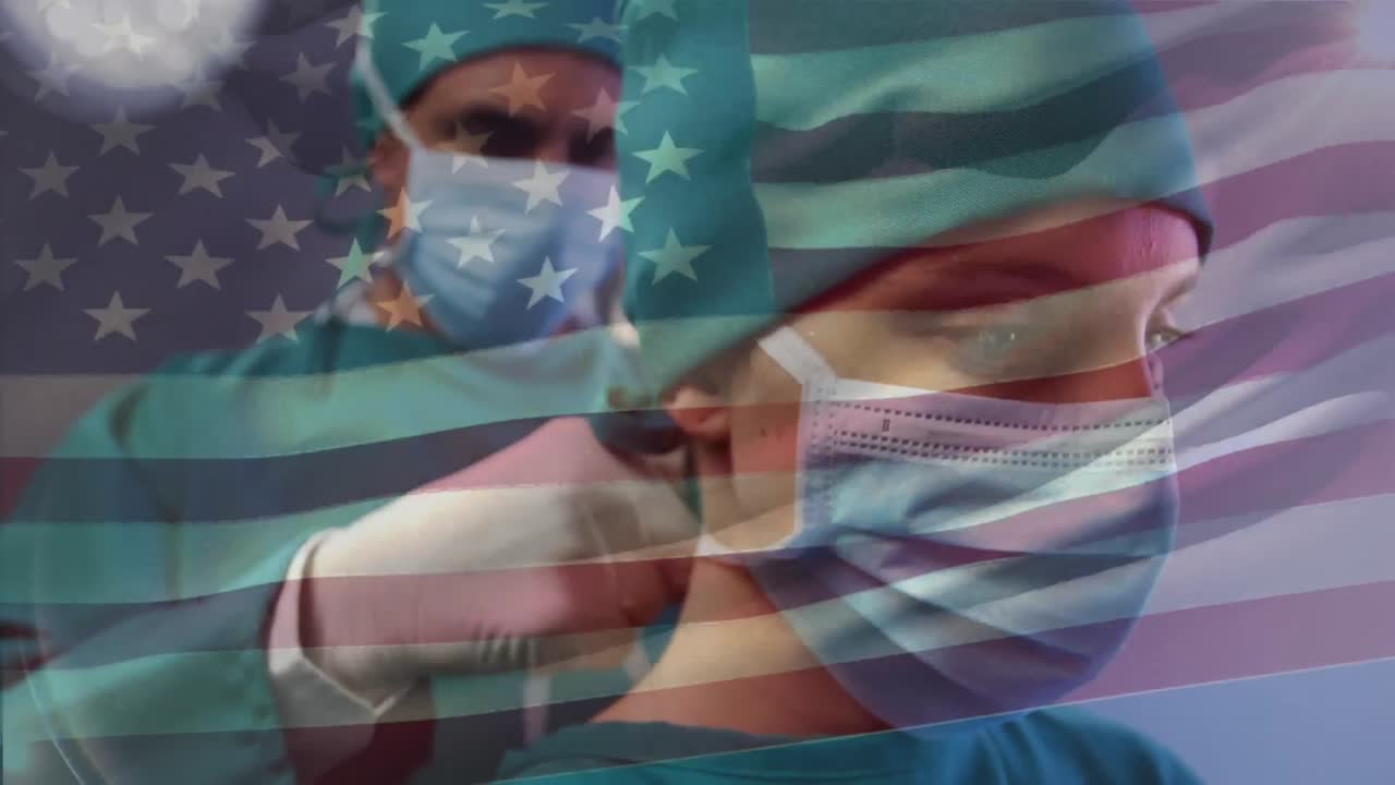 Animation of waving usa flag over male surgeon wearing surgical mask to female surgeon
