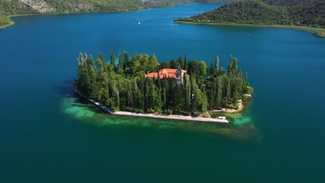 Vista-Aérea-Girando-Alrededor-De-La-Isla-Del-Monasterio-Visovac-En-El-Parque-Nacional-Krka-Con-Lagos-Y-Montañas-En-Dalmacia,-Croacia-Filmada-En-4k