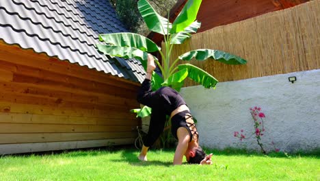 la chica haciendo yoga con un pie de cabeza en el césped