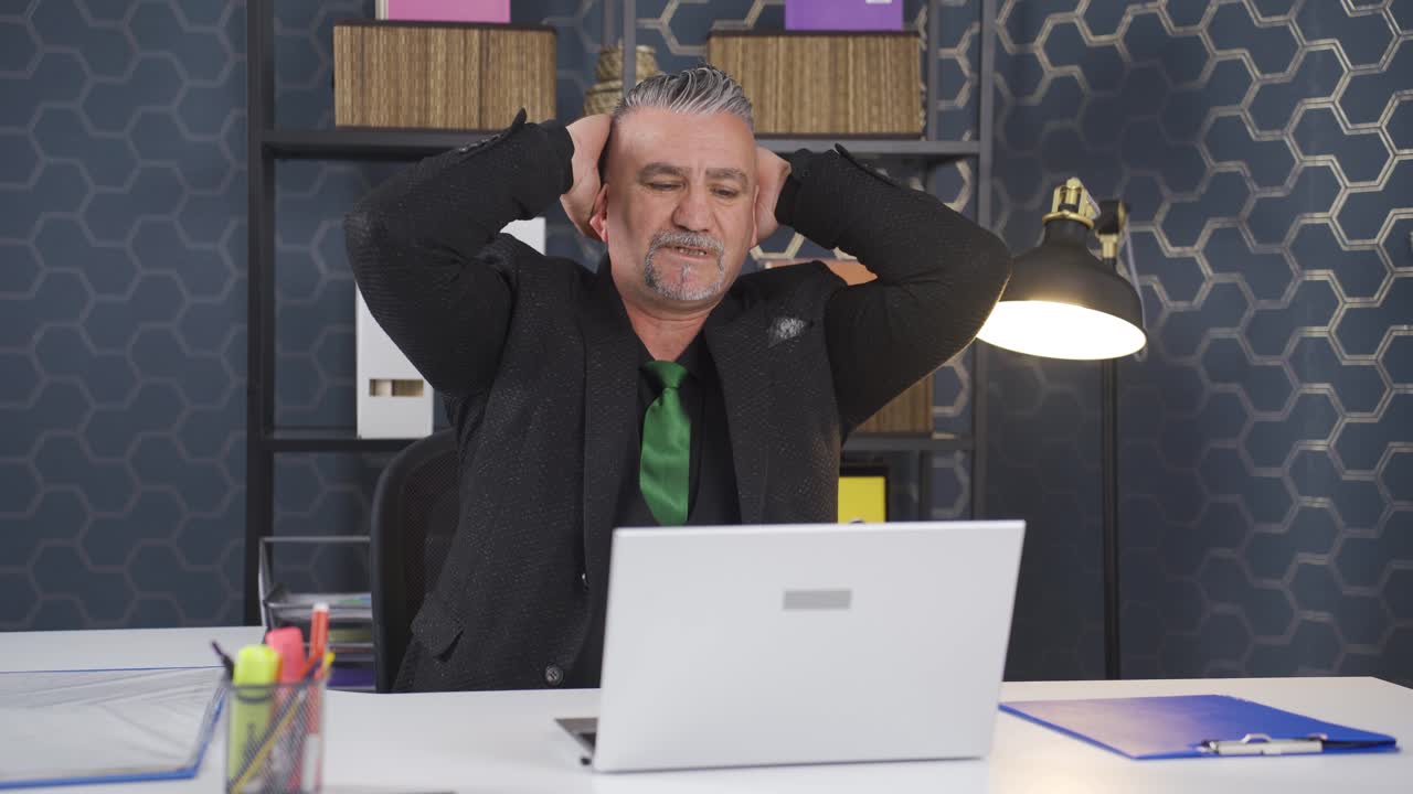 일에서 피곤한 사업가가 카메라를 쳐다보고 있습니다.